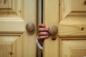 Hand of a child opening a cupboard door