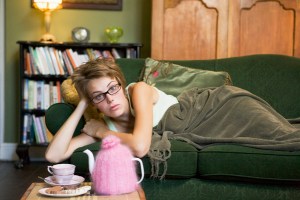 A young woman lying on her couch